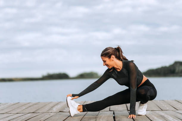 istock Smiling female athlete stretching before run outdoor. 1179956368