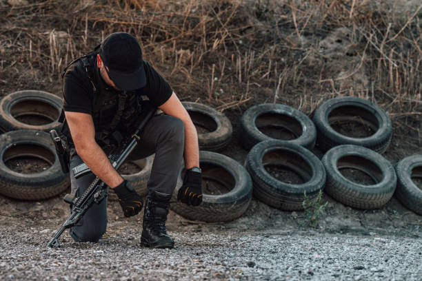 istock Armed man preparing for action, tying shoelace. 1179956419