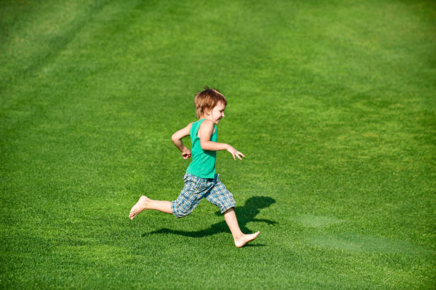 istock Happy boy running at the green golf course at sunny day 1179957848