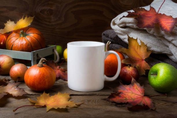 istock White coffee mug mockup with fall leaves, pumpkins 1179957851