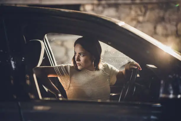 Photo of Young beautiful woman parking her car in reverse.