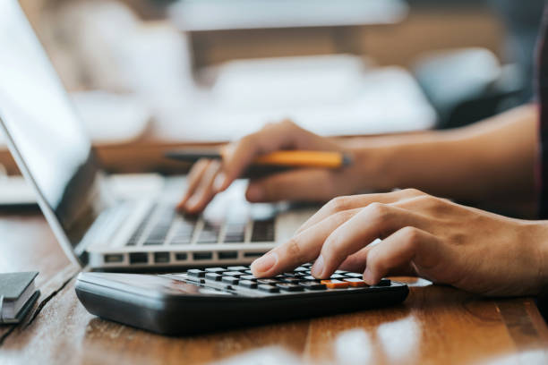 cierre las manos de los hombres usando una calculadora y una computadora portátil para calcular con papel financiero, impuestos, contabilidad, concepto de contador. - calculadora fotografías e imágenes de stock