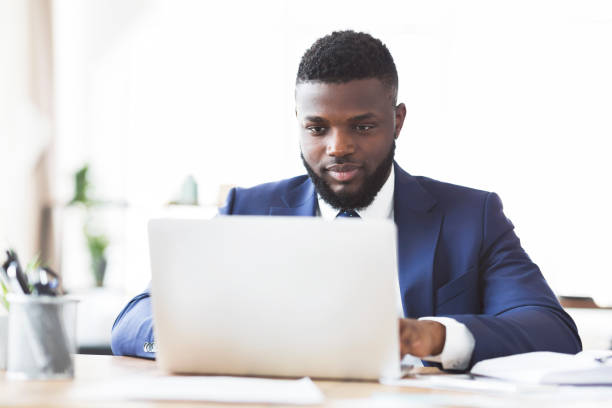 istock Hard-working black man typing on laptop in office 1179961877