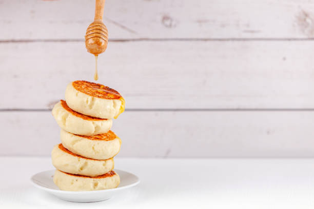 crêpes russes de fromage cottage de dessert - syrniki - avec la gorper de miel dégoulinante - cheesecake syrup cottage cheese cream photos et images de collection
