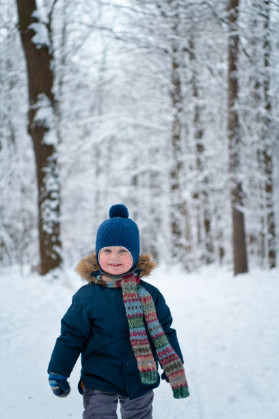 istock Happy child walking through winter forest 1179962592