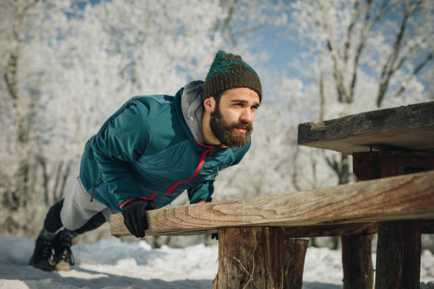 Young athlete exercising push-ups on a bench during winter day.