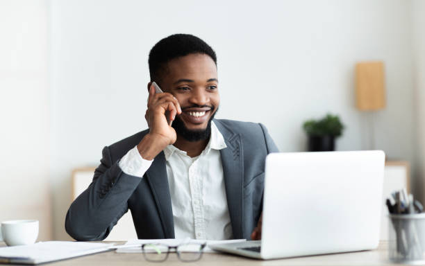 istock Happy african american employee talking on cellphone at office 1179962991