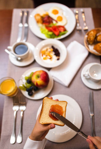 istock Young woman spreading jam on a toast 1179964246
