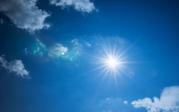 istock blue sky with clouds and sun shines bright in the day 1179964468