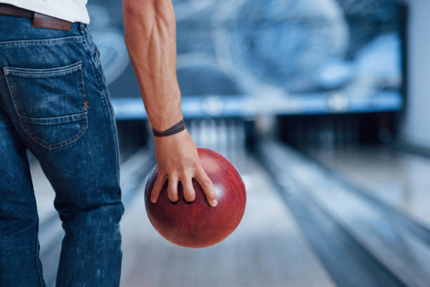 mãos fortes. opinião traseira da partícula do homem na roupa ocasional que joga o bowling no clube - bowling holding bowling ball hobbies - fotografias e filmes do acervo