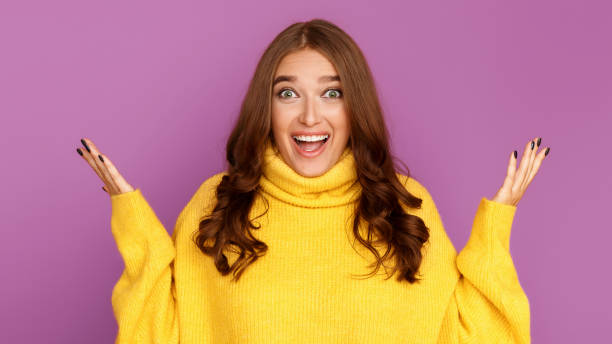 istock Surprised woman looking at camera, purple background 1179965609