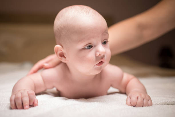 istock Cute baby boy on the bed trying to move 1179966024