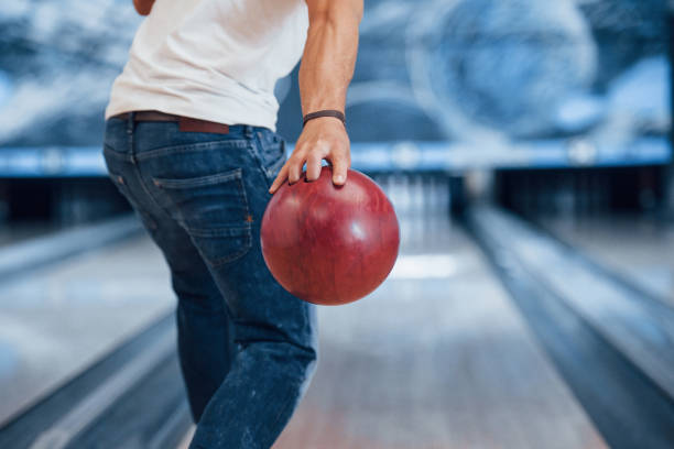 concepción de bolos. vista de partículas traseras del hombre con ropa casual en el club - bowling holding bowling ball hobbies fotografías e imágenes de stock