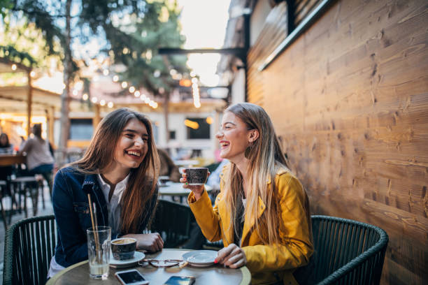 istock Young women sitting outdoors in cafe 1179968550