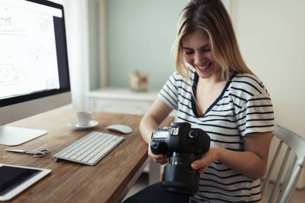 istock Young smiling beautiful designer holding digital camera 1179969478