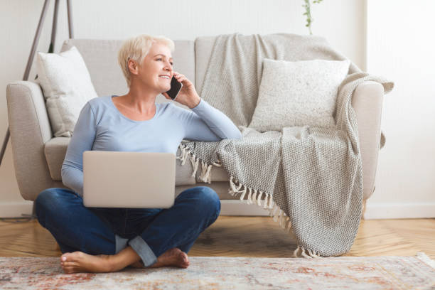 istock Joyful elderly business lady talking with clients, working at home 1179970179