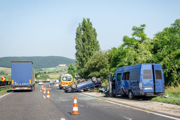 Car crash accident on highway. Damaged blue minibus after collision, overturned car and ambulance car on roadside. Traffic cones at accident site Car crash accident on highway. Damaged blue minibus after collision, overturned car and ambulance car on roadside. Traffic cones at accident site bus hungary stock pictures, royalty-free photos & images