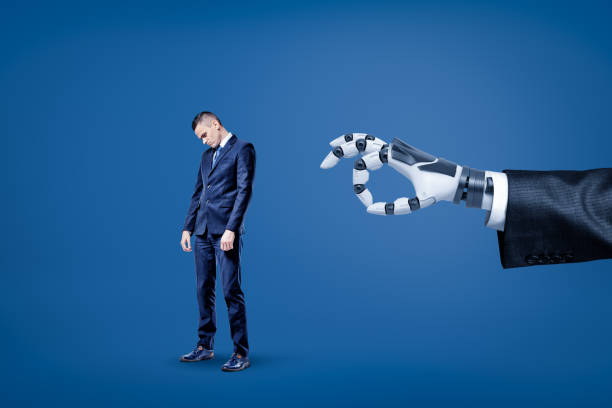 istock Big robotic hand ready to flick a small sad businessman on blue background 1179972895