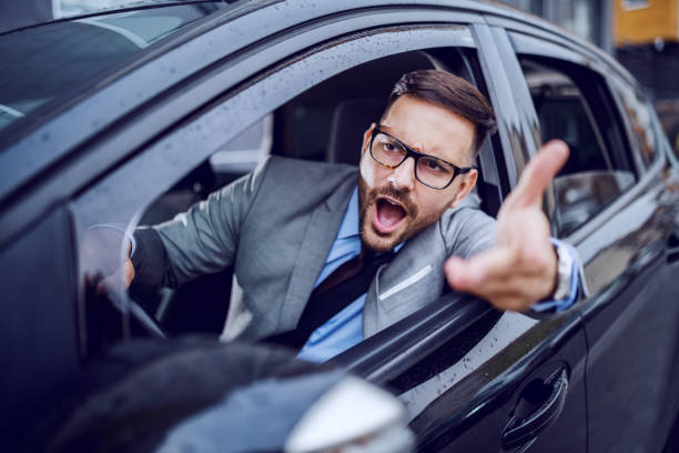 un uomo vestito acuto che si ritrova intrappolato in un'ora di punta e lentamente soccombe alla rabbia della strada. - food motivation driving drive foto e immagini stock