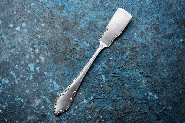 Top view of vintage silver cutlery or silverware on blue concrete background with copy space