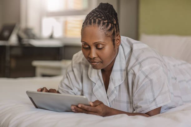 istock African American woman lying on her bed using a tablet 1179975262