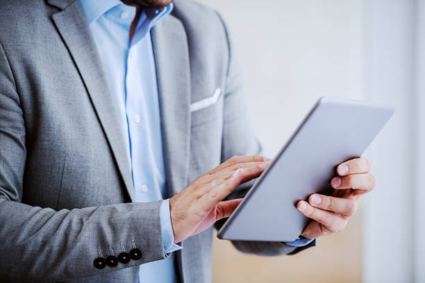 istock Close up of Caucasian businessman in suit using tablet. 1179975754