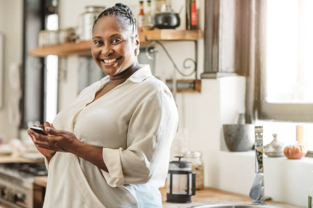 istock Smiling African American woman reading a text message at home 1179978193
