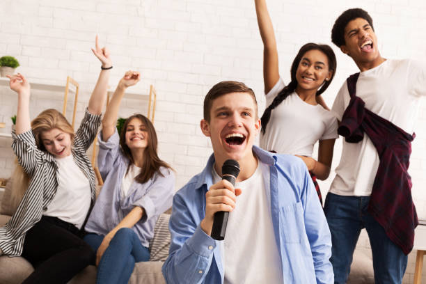 istock Playing karaoke. Friends having fun, singing songs 1179978689
