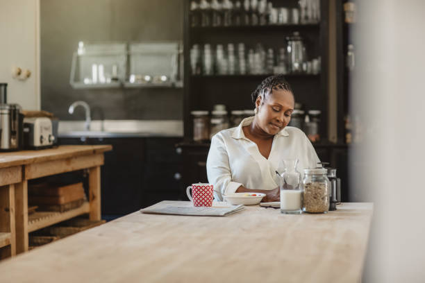 istock African American woman writing in her day planner over breakfast 1179978794