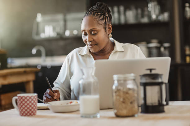 istock African American woman working at her kitchen table over breakfast 1179978830