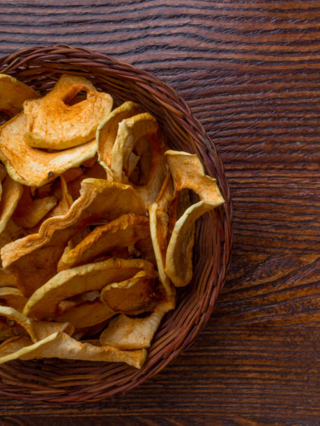 istock Top view of bowl with dried apple chips on wooden table 1179979596