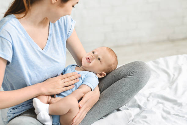 istock Young mother lulling her adorable baby boy on laps 1179979679