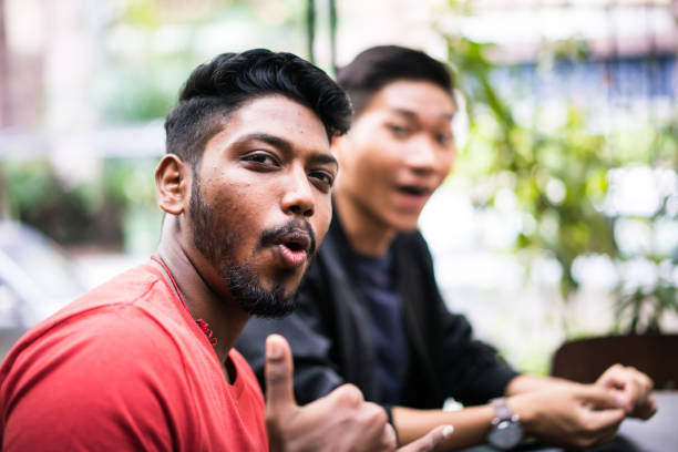 Indonesian southeast asian man relaxed while drinking a cup of coffee with an outdoor background. Making coffee activity