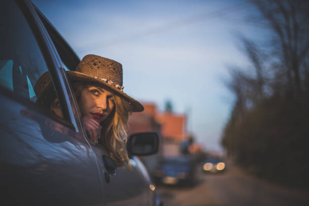 istock Smiling woman looking through the car window on a sunny day 1179981076