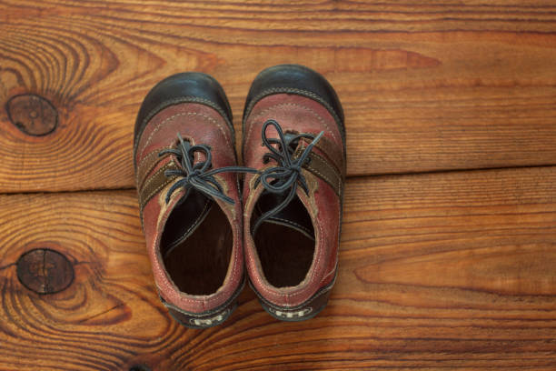 istock Leather kids boots on a wooden background top view with copy space. 1179988684