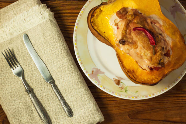 istock Pumpkin half stuffed with chicken breast and pepper on a wooden background. 1179988689
