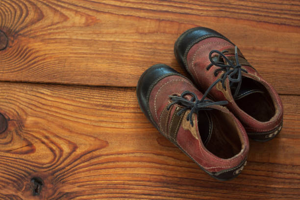 istock Leather kids boots on a wooden background top view with copy space. 1179988743