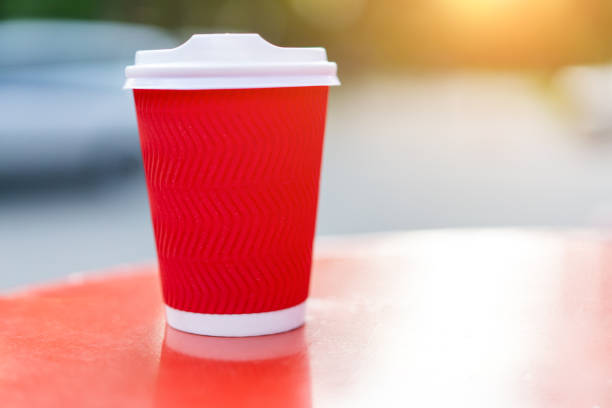 istock Red paper cup for drinks on a background of nature. 1179989625