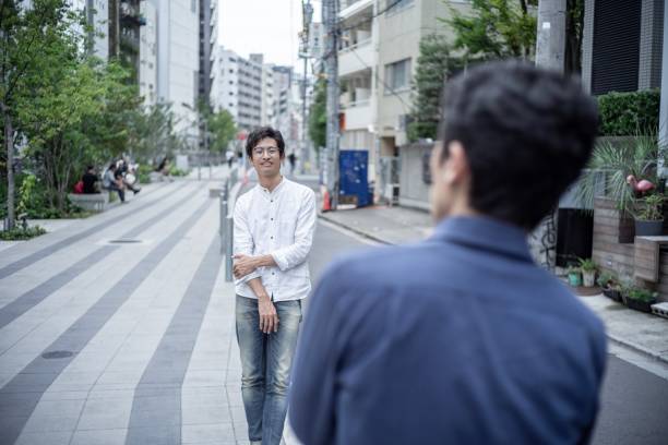 istock Two asian men talking face to face outdoor 1179990540