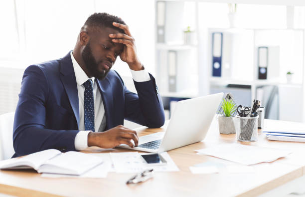 istock Exhausted young entrepreneur working with laptop in office 1179991016