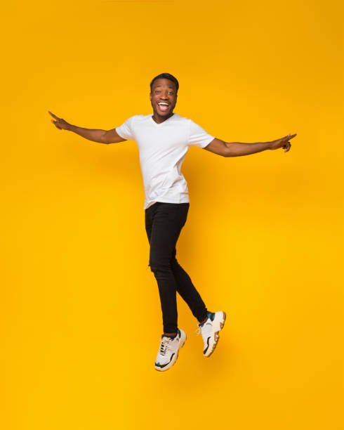 istock African American Guy Jumping Having Fun Over Yellow Background 1179991175