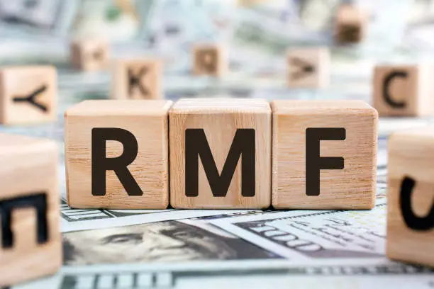 RMF - acronym from wooden blocks with letters, abbreviation LTF Long-Term Equity Mutual Fund and RMF Retirement Mutual Fund concept, random letters around, money background
