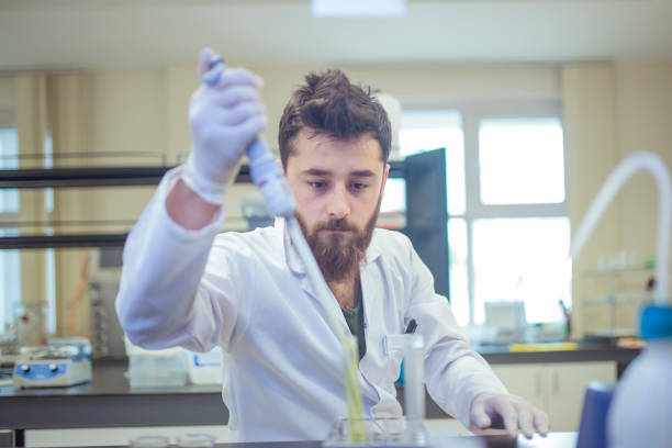 istock Young male lab intern concentrates during experiment 1179992368