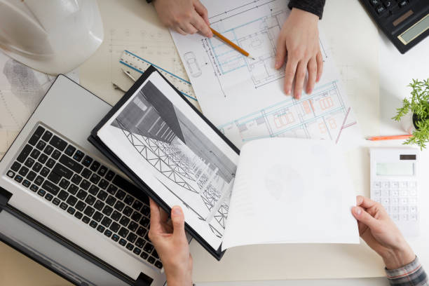 istock Architects working on blueprint, real estate project. Architect workplace - architectural project, blueprints, ruler, calculator, laptop and divider compass. Construction concept. Engineering tools. 1179992671