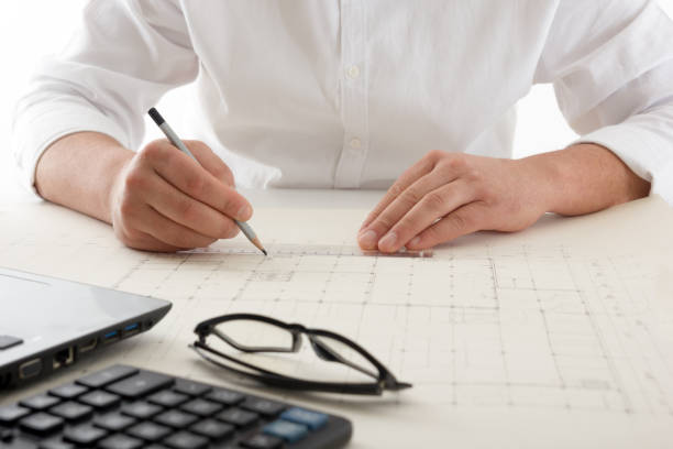 istock Architects working on blueprint, real estate project. Architect workplace - architectural project, blueprints, ruler, calculator, laptop and divider compass. Construction concept. Engineering tools. 1179992736