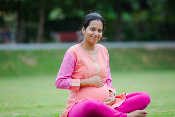 Smiling pregnant woman in a park. stock photo Pregnant, Child, Young Adult, South Indian, south indian lady stock pictures, royalty-free photos & images