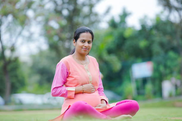 Smiling pregnant woman in a park. stock photo Pregnant, Child, Young Adult, South Indian, south indian lady stock pictures, royalty-free photos & images