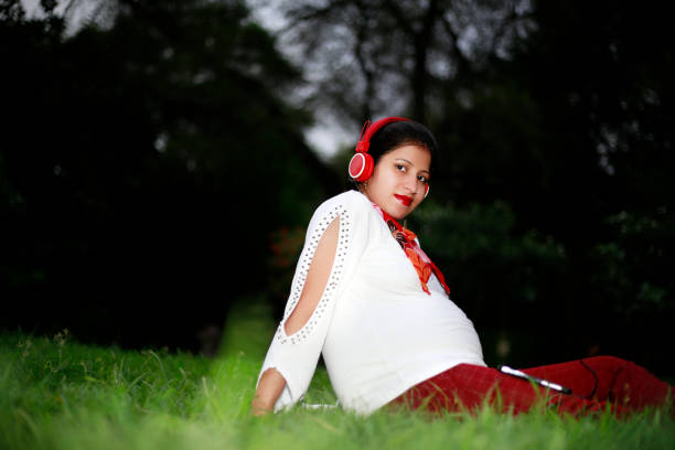 индийские беременные женщины слушают музыку в природе - new delhi audio стоковые фото и изображения