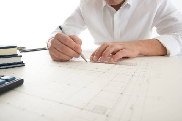istock Architects working on blueprint, real estate project. Architect workplace - architectural project, blueprints, ruler, calculator, laptop and divider compass. Construction concept. Engineering tools. 1179993368