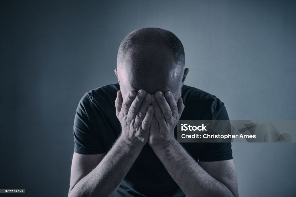Disappointment or Depression Shocked, stressed, depressed or plain tired mature man with head in hands. Post-traumatic stress disorder Stock Photo